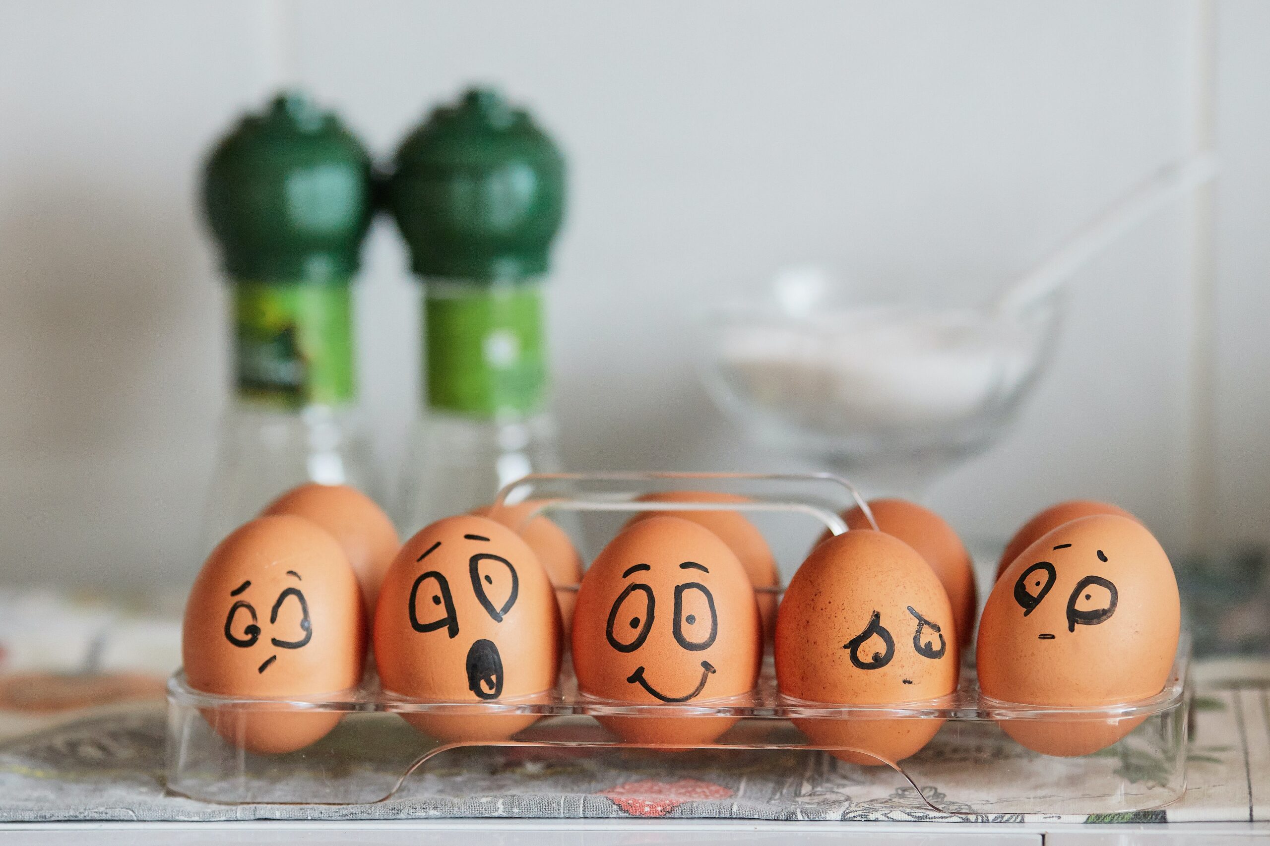 Eggs with faces drawn on expressing emotions: sad, unsure, happy, shocked