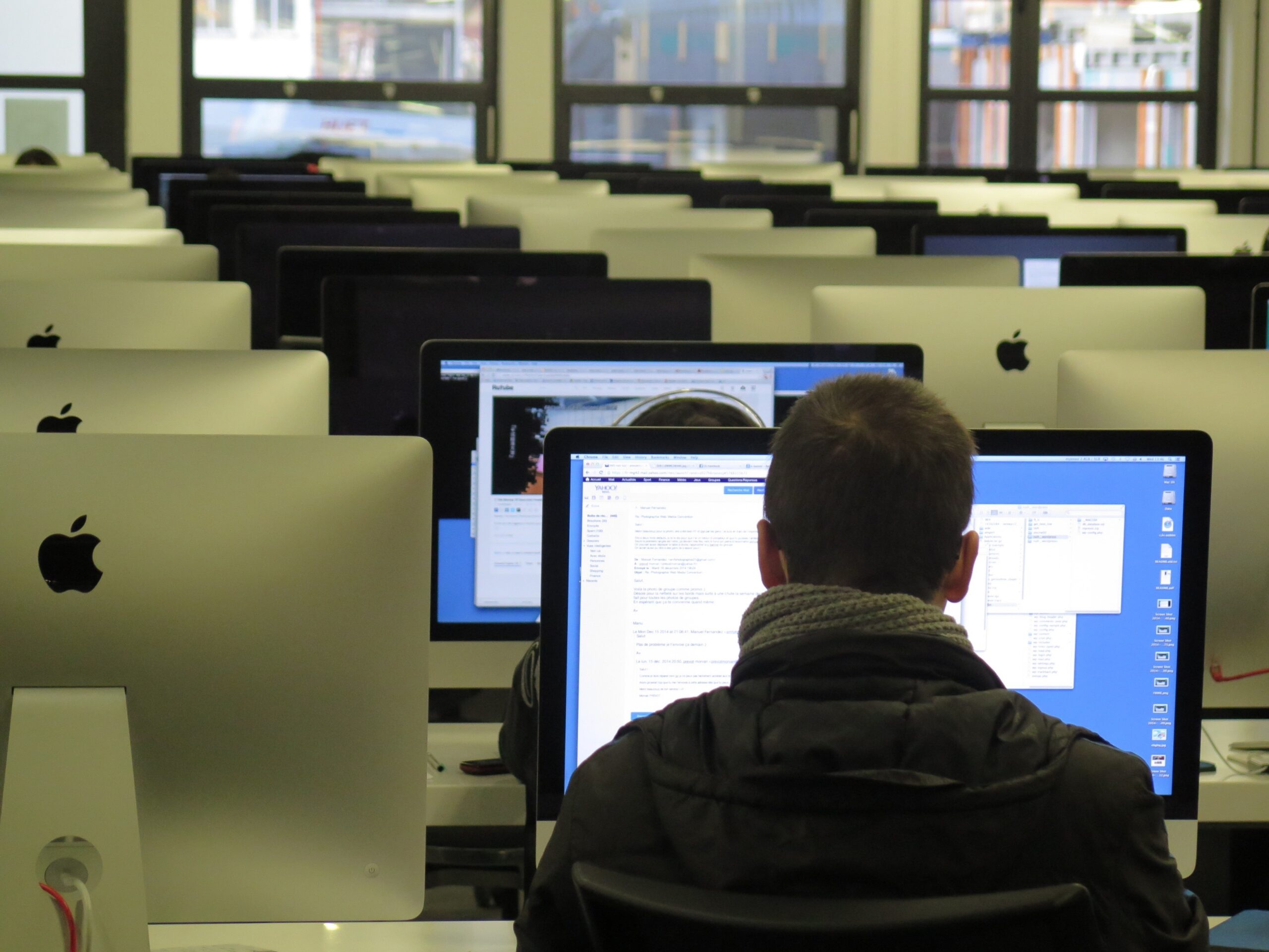 Room with lots of computers. A student is sat with their back to us.